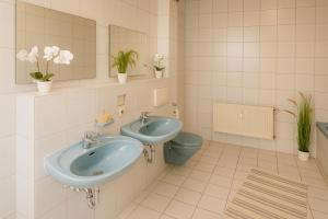 a bathroom with two sinks and a toilet at SUNNYHOME Monteurwohnungen und Apartments in Schwandorf in Schwandorf in Bayern