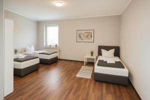 two beds in a room with wooden floors at SUNNYHOME Monteurwohnungen und Apartments in Schwandorf in Schwandorf in Bayern