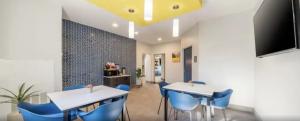 uma sala de jantar com duas mesas e cadeiras azuis em Park Inn by Radisson em Grand Island