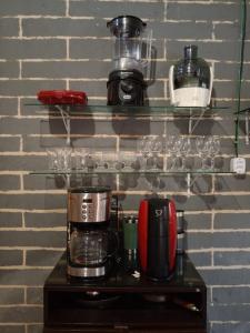 un estante con una cafetera y tazas. en Quarto completo, en Ananindeua