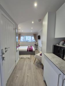 a room with a bedroom with a bed and a kitchen at Pro Stay Studio in Fort William