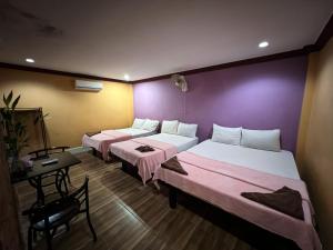 a room with two beds and a table and a desk at Moon Ratanak in Banlung +21 photos