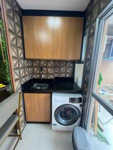 una piccola cucina con lavatrice e lavandino di Ap Setor universitário a Goiânia