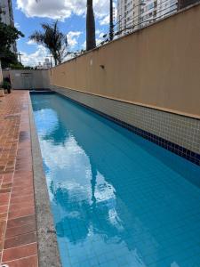 una piscina con piastrelle blu sul lato di un edificio di Ap Setor universitário a Goiânia