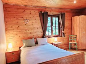 a bedroom with a bed and a wooden wall at Gite de Liresse 