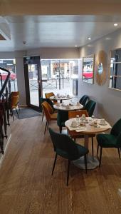 a dining room with tables and chairs in a restaurant at Le Faidherbe Hotel Coeur de ville in Boulogne-sur-Mer