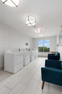 een kamer met witte wasmachines en blauwe stoelen bij Hilton Garden Inn New Braunfels in New Braunfels