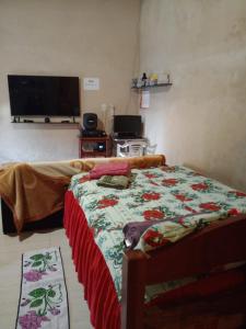 Un dormitorio con una cama y un televisor de pantalla plana. en Quarto completo, en Ananindeua