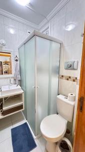 a bathroom with a toilet and a shower and a sink at Apartamento na praia in Balneário Camboriú