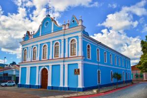 a blue and white building on the side of a street at Grande Hotel Amparo in Amparo