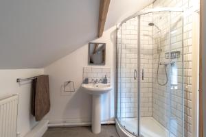 ein Badezimmer mit Waschbecken und Dusche in der Unterkunft Prince Rupert's cottage with garden in Sibbertoft + 21 Fotos