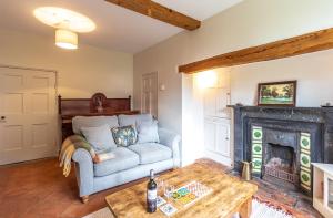 ein Wohnzimmer mit Couch und Kamin in der Unterkunft Prince Rupert's cottage with garden in Sibbertoft