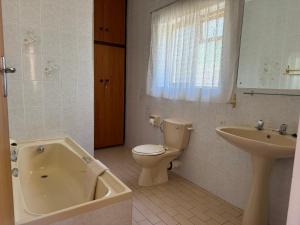 a bathroom with a tub and a toilet and a sink at Amia in Witsand +22 photos