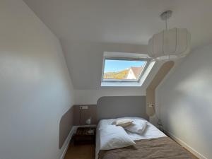 a small bedroom with a bed and a window at Le Kintz' in Kintzheim