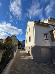 a white building on a street with a blue sky at Le Kintz' in Kintzheim