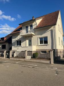 a white house with a balcony on a street at Le Kintz' in Kintzheim +13 photos