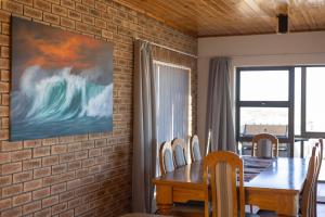 a dining room with a brick wall and a table and chairs at Amia in Witsand