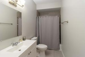 un bagno bianco con wc e doccia di Modern & Spacious 3bd 3ba RoofDeck a Washington Altre 10 foto