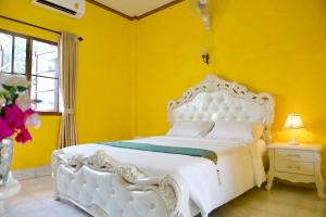 a bedroom with a white bed in a yellow wall at จักรพันธ์วอลเลย์ in Ban Bang Toei (1)