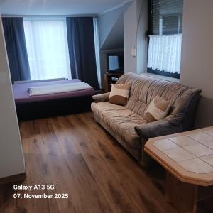 a living room with a couch and a bed at Pension Strohm im Lieth Café in Bad Fallingbostel