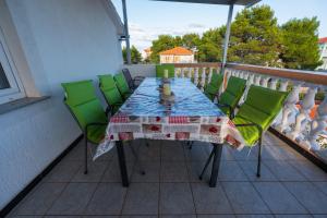 - Balcón con mesa y sillas verdes en Apartmani-Finka, en Vodice 48 fotos más