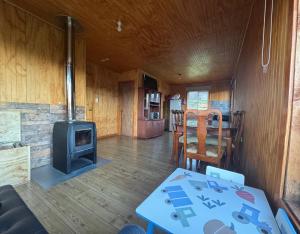 a living room with a stove and a table at Cabaña Pueblo Hundido in Futrono