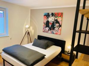 a bedroom with a bed with a painting on the wall at Ferienwohnung & Monteurunterkunft Mainbogen-Blick in Grettstadt +3 photos