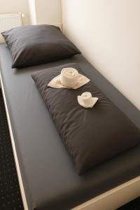 twee hoeden zitten op een bed bij Business Apartments Augsburg mit WIFI, TV, Parken in Augsburg