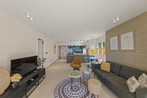 un salon avec un canapé et une table dans l'établissement The Strand apartment for 5 guests with pool and beach, à Willemstad