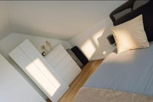 a bedroom with a white bed and a white pillow at Ferienwohnung Fehnzeit in Rhauderfehn