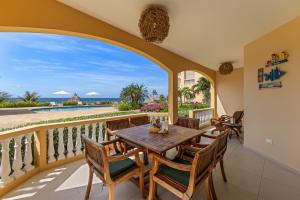 une salle à manger avec une table et des chaises sur un balcon dans l'établissement The Strand apartment for 5 guests with pool and beach, à Willemstad