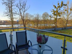 a balcony with a table and chairs and a view of a river at Oaza spokoju - Walendów in Walendów
