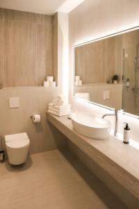 a bathroom with a sink and a toilet and a mirror at Hotel Karting in Mostar +42 photos
