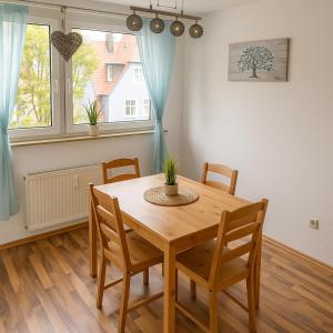 een eetkamer met een houten tafel en stoelen bij SUNNYHOME Monteurwohnungen und Apartments nahe Regensburg in Nittendorf