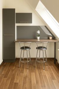 een keuken met twee krukken en een tafel onder een trap bij SUNNYHOME Monteurwohnungen und Apartments nahe Regensburg in Nittendorf