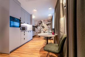 a kitchen with a white table and a table and chairs at Hotel Am Triller - Hotel & Serviced Apartments - Pool & Relax Lounge in Saarbrücken +132 photos