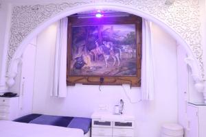 a bedroom with a painting on the wall above a bed at House of Raghuvansh in Jodhpur
