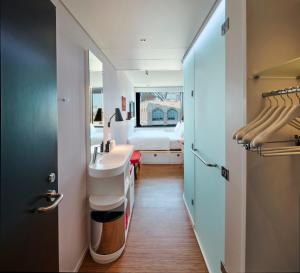 uma casa de banho com um lavatório e um quarto com uma cama em citizenM Boston Back Bay em Boston