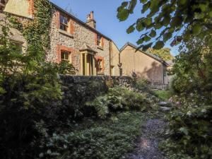 une vieille maison en pierre avec un jardin devant dans l'établissement Rock Cottage, à Storth