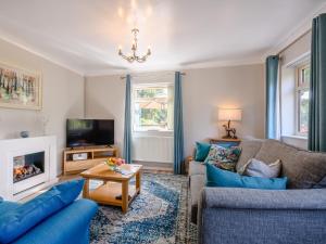 a living room with a couch and a tv at Paddock End in Great Plumstead