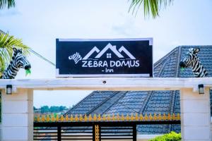 a sign on top of a building with zebras on it at Zebra Domus in Huye