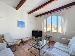 a living room with a couch and a tv at Grande maison avec vue mer et jacuzzi au cœur de Calvi in Calvi