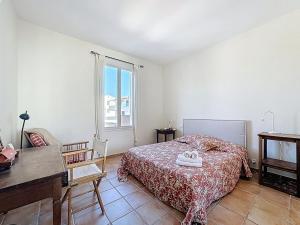 a bedroom with a bed and a desk and a window at Grande maison avec vue mer et jacuzzi au cœur de Calvi in Calvi