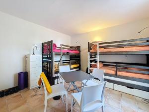 a room with a table and chairs and bunk beds at Grande maison avec vue mer et jacuzzi au cœur de Calvi in Calvi