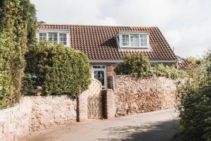 a brick house with a stone wall at Charming 2-Bed House by Brookland Stays in Jersey Free Wi-Fi & Parking Included 
