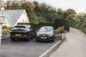 two cars parked next to each other in a driveway at Charming 2-Bed House by Brookland Stays in Jersey Free Wi-Fi & Parking Included  +4 photos