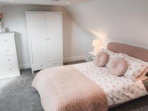 a bedroom with a large bed with two pillows at Charming 2-Bed House by Brookland Stays in Jersey Free Wi-Fi & Parking Included 
