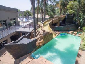a swimming pool with a slide in a resort at Silva Villa in Bedfordview