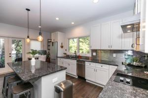a kitchen with white cabinets and granite counter tops at Skyline Views, Mins To Downtown in Atlanta +26 photos