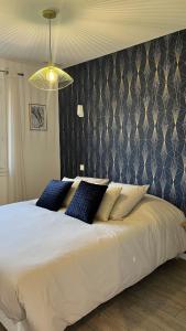 a bedroom with a large white bed with blue pillows at La maison d a cote in Éguzon-Chantôme +37 photos
